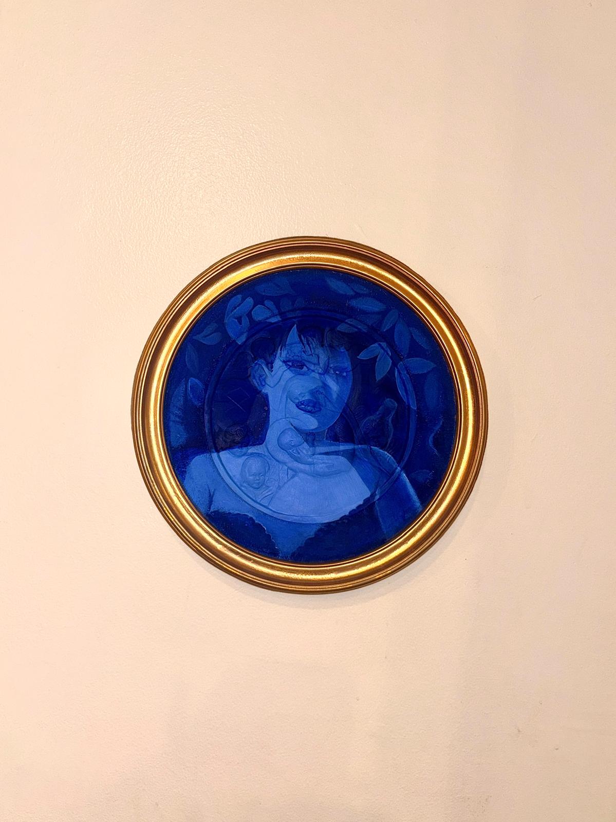 Round blue portrait of a woman in an ornate gold frame