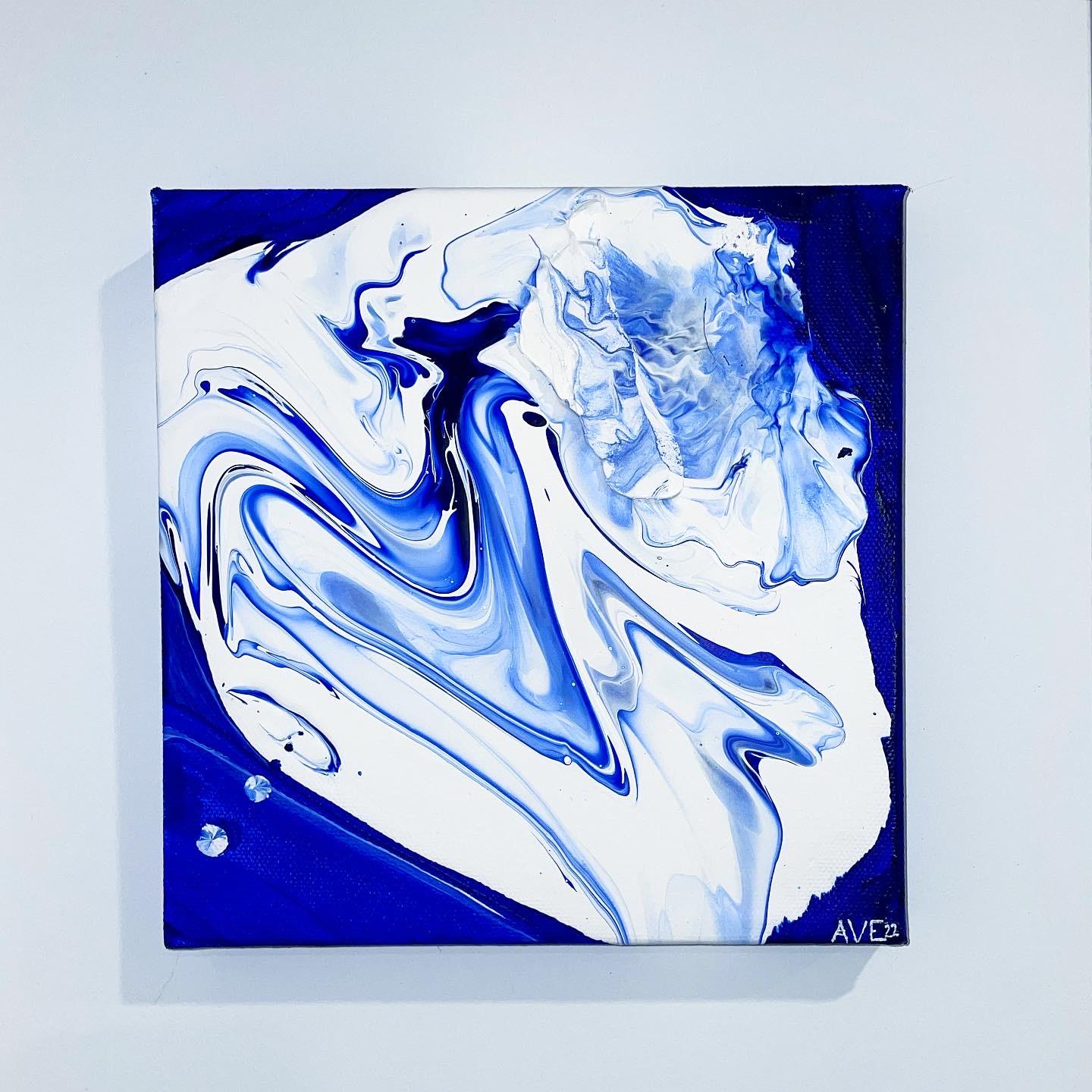 Poured white and blue paint on a square canvas