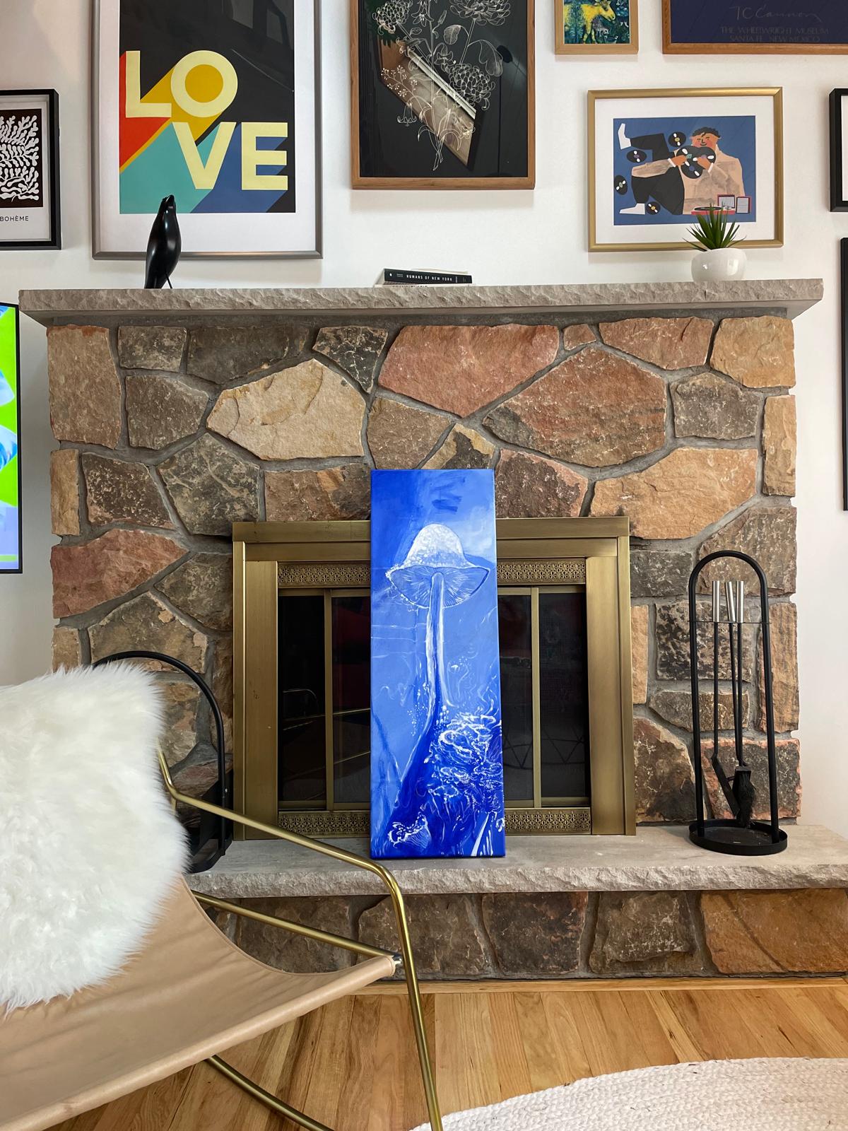 Tall blue mushroom painting on a stone fireplace
