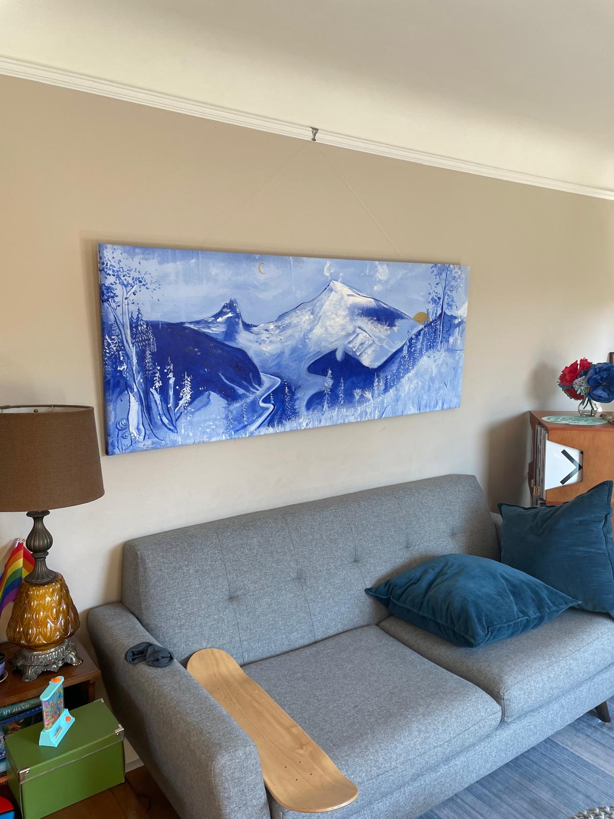 Blue mountain panorama hanging above a sofa