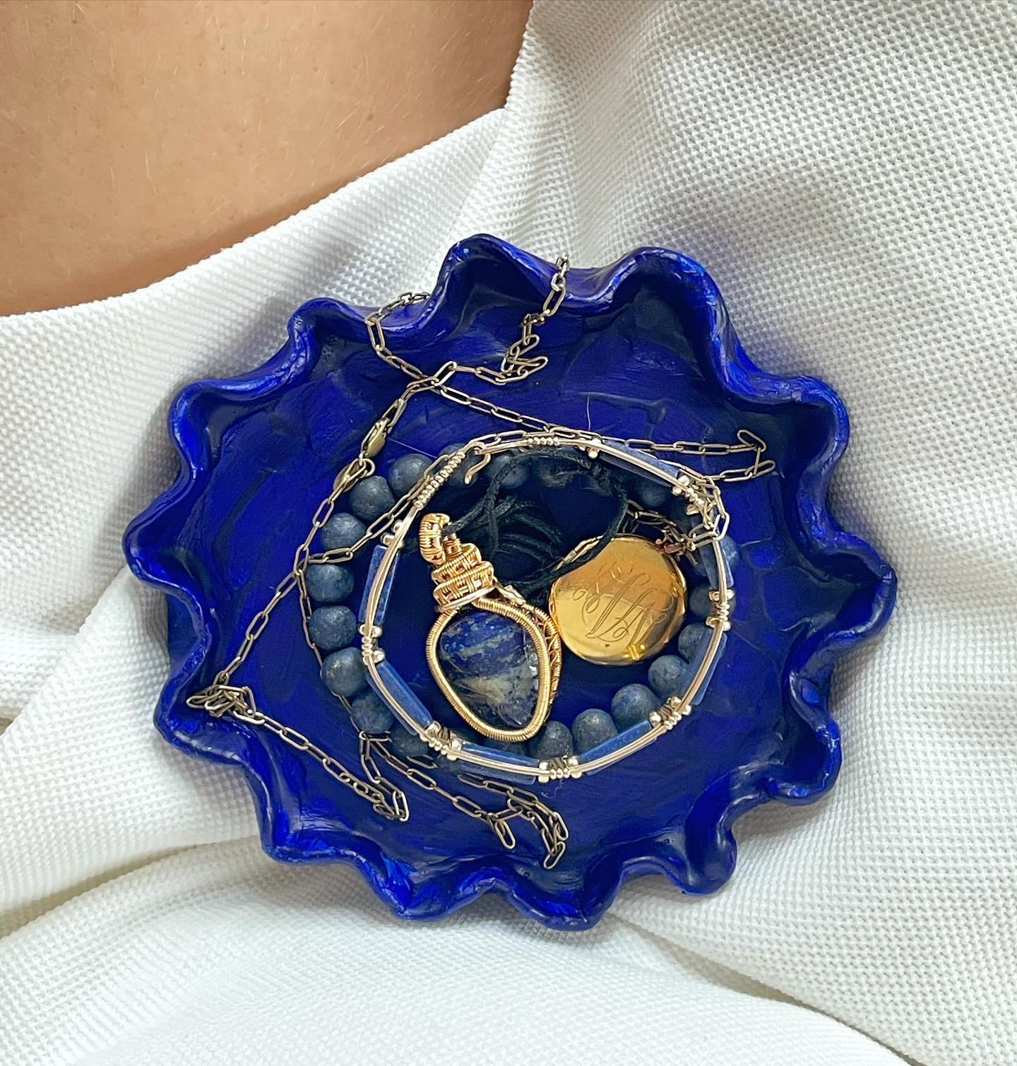 Scalloped cobalt trinket dish holding jewelry