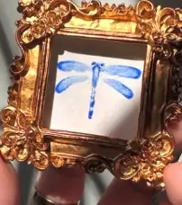 Blue dragonfly in a small ornate gold frame