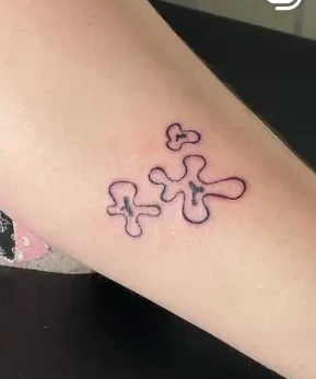 Small organic outline motifs tattooed on skin