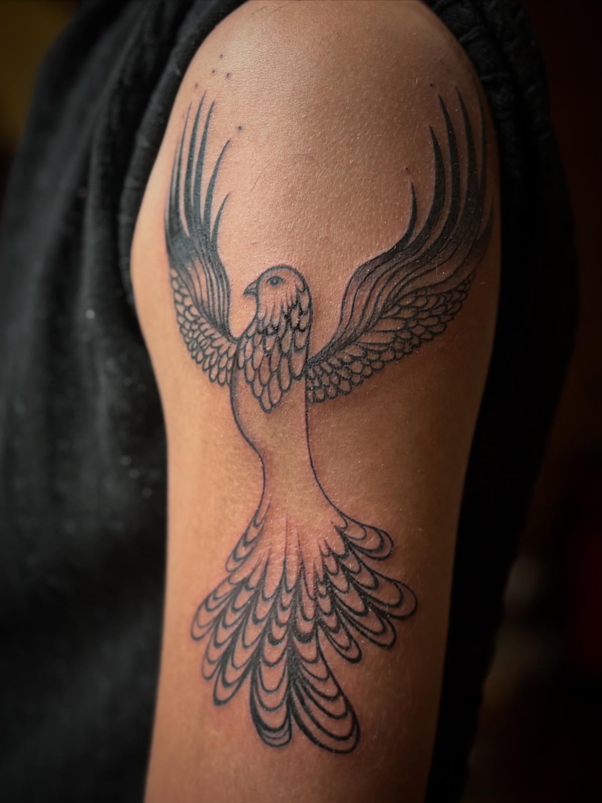 Phoenix with outstretched wings tattooed on a shoulder