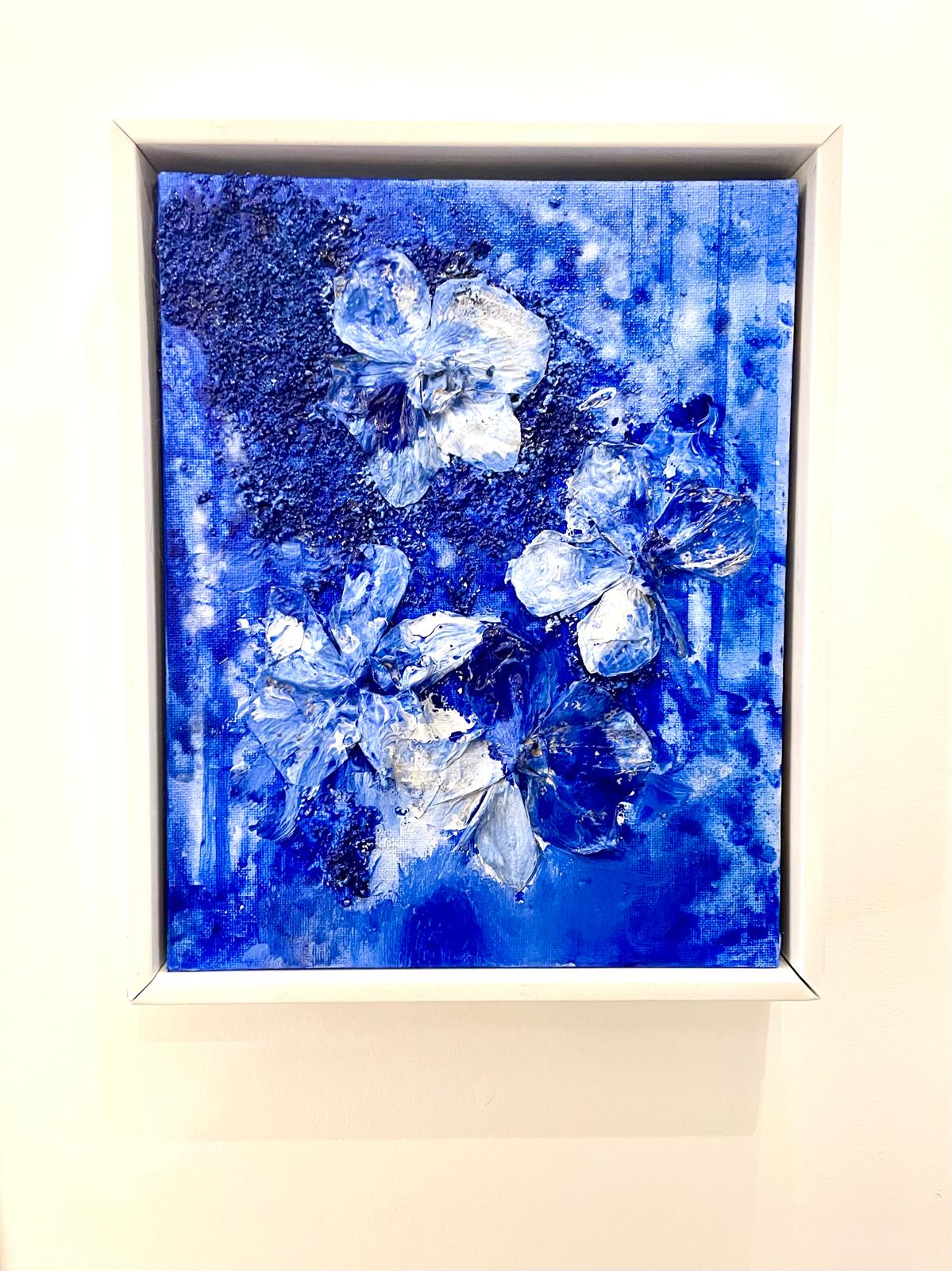 Textured white flowers on a deep blue ground in a white frame