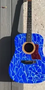 Acoustic guitar painted with cobalt blue water-like patterns